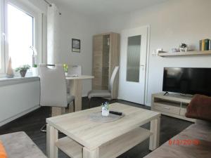 a living room with a coffee table and a television at One-bedroom apartment in Leherheide