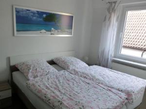 a bed in a bedroom with a picture on the wall at One-bedroom apartment in Leherheide
