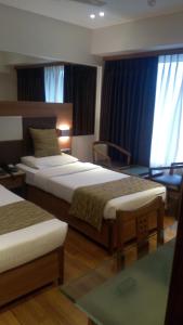 Postel nebo postele na pokoji v ubytování The Royal Orchid Hotel, Chembur