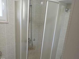 a shower with a glass door in a bathroom at Apartments Julia - Studio Apartment Julia 1 in Martinšćica