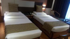 Postel nebo postele na pokoji v ubytování The Royal Orchid Hotel, Chembur