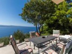 Una mesa y sillas en un patio con vista al mar. en Apartments Roma - Two Bedroom Apartment, en Celina