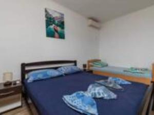 Un dormitorio con una cama con sábanas azules y almohadas azules. en Apartments Roma - Two Bedroom Apartment, en Celina