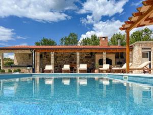 a swimming pool with a patio with chairs and a house at Villa Maria with Outdoor Pool - Five Bedroom Villa with Outdoor Pool in Otavice