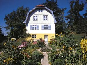 a yellow and white house with a garden of flowers at Holiday apartment with 2 bedrooms in Oberammergau