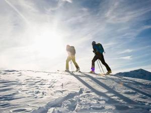 two people are skiing down a snow covered slope at Holiday apartment with 2 bedrooms in Oberammergau