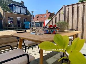a wooden table and chairs on a patio at Holiday Home in Petten near the Beach in Sint Maartensvlotbrug