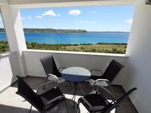 a table and chairs in a room with a large window at One-Bedroom Apartment A1 in Stošići