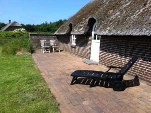 a bench sitting in front of a brick building at Holiday home in Ulfborg with swimming pool in Vedersø Klit