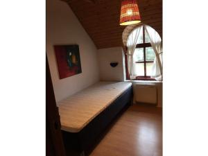 a small bed in a room with a window at Holiday home in Ulfborg with swimming pool in Vedersø Klit