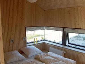 een slaapkamer met twee bedden en een raam bij Holiday home in Thisted with swimming pool in Nørre Vorupør