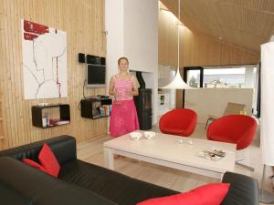 een vrouw in een roze jurk staand in een woonkamer bij Holiday home in Thisted with swimming pool in Nørre Vorupør +10 foto's