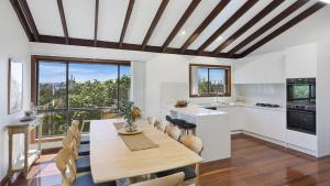 a kitchen and dining room with a table and chairs at Sunset On View - Picturesque Coastal Setting With Pool in The Entrance