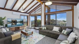 a living room with a couch and a tv at Sunset On View - Picturesque Coastal Setting With Pool in The Entrance