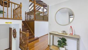 a living room with a staircase and a mirror at Sunset On View - Picturesque Coastal Setting With Pool in The Entrance +8 photos