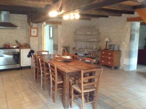 kuchnia z dużym drewnianym stołem i krzesłami w obiekcie Gite du Calme 3 Star Bed & Breakfast Cognac w mieście Chérac