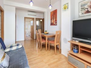 un soggiorno con tavolo da pranzo e televisione di Peaceful Nature Retreat Near Krk Town with BBQ and Parking - Standard Two Bedroom Apartment a Vrh