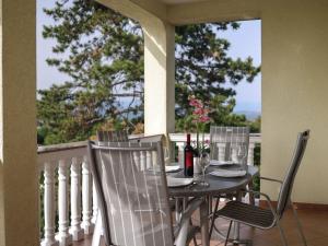 un tavolo e sedie su un balcone con vista di Peaceful Nature Retreat Near Krk Town with BBQ and Parking - Standard Two Bedroom Apartment a Vrh