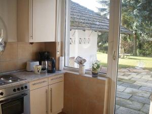 a kitchen with a stove top oven next to a window at Lense, with piano in Stephanshausen
