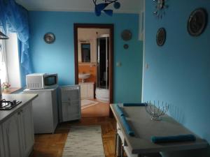 a blue kitchen with a table and a microwave at on the Baltic Sea in Kolobrzeg - Grzybowo in Grzybowo