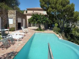 Una gran piscina con sillas y una casa. en 1-bedroom villa in Cote d'Azur, en Cavalaire-sur-Mer