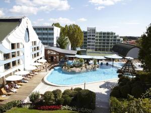 a large swimming pool with umbrellas and a building at Apartment in Hévíz with swimming pool in Hévíz