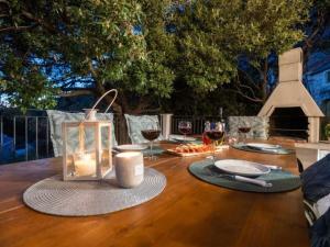 una mesa de madera con una vela y copas de vino en Villa in Makarska with swimming pool, en Kotišina