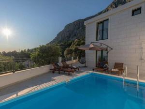 una casa con piscina al lado de un edificio en Villa in Makarska with swimming pool, en Kotišina