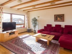 a living room with a red couch and a table at Holiday home with 3 bedrooms in Frutenhof