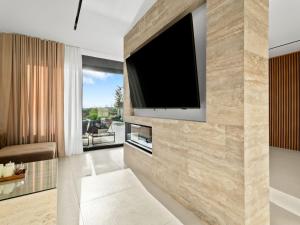un soggiorno con una TV a schermo piatto su una parete di Villa Freedom - Five Bedroom House with Balcony a Mala Čista