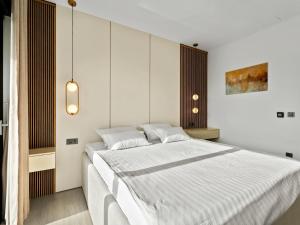 una camera da letto con un letto grande con lenzuola bianche di Villa Freedom - Five Bedroom House with Balcony a Mala Čista Altre 32 foto