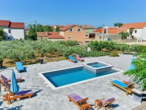 una piscina con sedie a sdraio e una piscina di Apartments Franica with Heated Pool and Hot-Tub - Two Bedroom Apartment with Balcony a Privlaka (Brevilacqua) Altre 16 foto