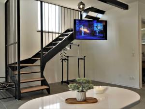 a living room with a spiral staircase with a tv on the wall at Tranquil Luxe Thermal Escape Mobile Home - Premium Mobile Home with Terrace in Mostec