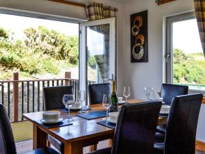 a dining room with a table with wine glasses at The Greenkeeper - Uk39823 in Portpatrick