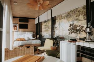 a bedroom with a bed and a living room at The Bambino - By Casa Bicheno in Bicheno