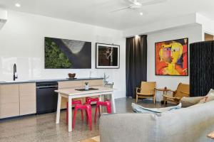 Una cocina y una sala de estar con mesa y sillas. en C & C by the Sea Studio, en Coolum Beach