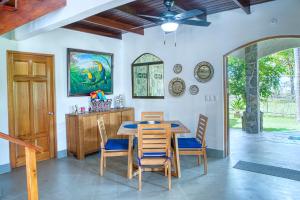 a dining room with a wooden table and chairs at Mariposa Monarca in Esterillos
