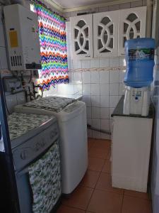 a kitchen with a stove and a washing machine at Magenta departamentos in Constitución