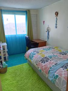 a bedroom with a bed and a desk and a window at Magenta departamentos in Constitución