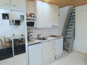 a kitchen with white cabinets and a sink at Levin KUURA in Kittilä