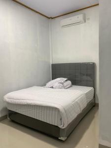 a bed in a white room with a white mattress at Champrink Surfcamp in Wainapal