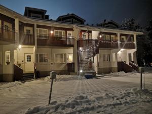 a house with snow in front of it at night at Levin KUURA in Kittilä