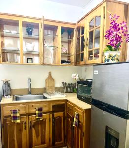 a kitchen with wooden cabinets and a refrigerator at City Siesta in Kingston +6 photos