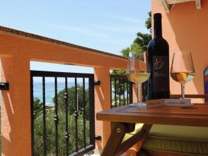 una mesa con 2 copas de vino en el balcón en Apartments Denona, en Novalja
