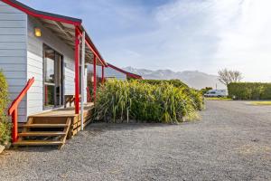 a building with a porch and some plants next to it at Kaikōura TOP 10 Holiday Park in Kaikoura