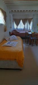 ein Schlafzimmer mit einem Bett, einem Tisch und einer Couch in der Unterkunft departamentos valle escondido in Villa Yacanto + 25 Fotos