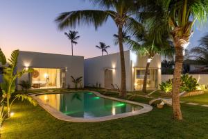 a villa with a swimming pool in front of a house at Pousada Vila Nazare in São Miguel do Gostoso