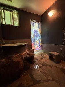 une salle de bain avec une baignoire et une porte de douche en verre dans l'établissement Oceanview 16 IKI, à Iki 32 autres photos