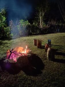un foyer extérieur dans un champ la nuit dans l'établissement Casa Campestre Claro de Luna - Fusagasugá, à Fusagasuga