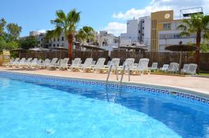 une piscine avec des chaises longues et une piscine dans l'établissement Hotel Apartamentos Vibra Central City - Adults only, à Sant Antoni de Portmany